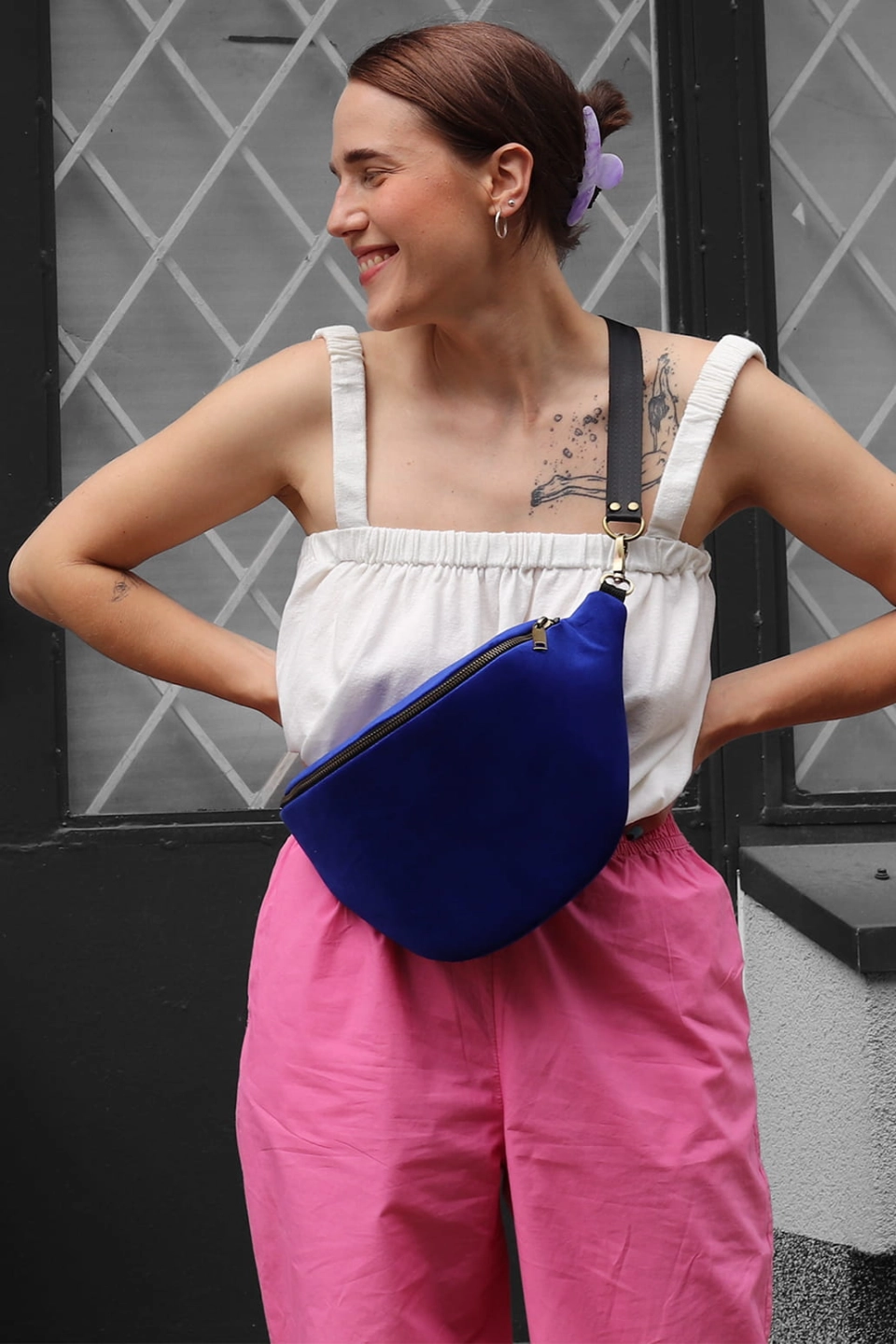 Chabrowa nerka aksamitna Dazzling Blue. Trwały materiał. Okucia w starym złocie. Modelka prezentuje rozmiar maxi, wraz z paskiem z czarnej taśmy 25mm.