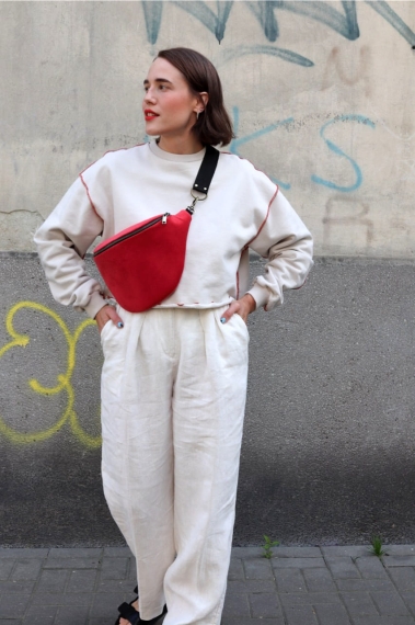 Elegancka czerwona nerka Hibiskus. Trwały aksamit. Okucia stare złoto. Prezentowana przez modelkę w rozmiarze maxi, z paskiem z czarnej taśmy 25mm. Noszona na skos, przez ramię.