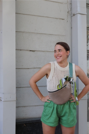 Jasnobeżowa nerka Oxford Tan. Trwały aksamit. Okucia w starym srebrze. Prezentowana przez modelkę w rozmiarze midi, z paskiem z taśmy 40mm w kolorze szara mięta.