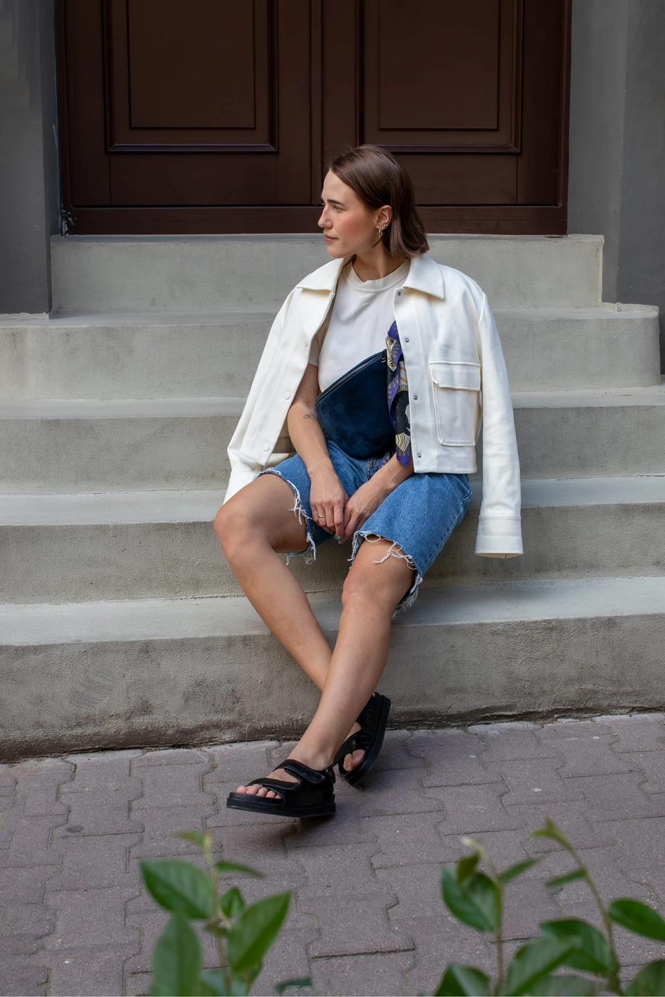 Nerka Black Iris z ciemnogranatowego aksamitu. Metalowy suwak i okucia pasków - stare złoto.  Prezentowana w rozmiarze midi, z paskiem z czarnej taśmy 25mm. Noszona na skos, przez ramię. Ozdobiona kolorową apaszką.