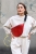 Elegancka czerwona nerka Hibiskus. Trwały aksamit. Okucia stare złoto. Prezentowana przez modelkę w rozmiarze maxi, z paskiem z czarnej taśmy 25mm. Noszona na skos, przez ramię.