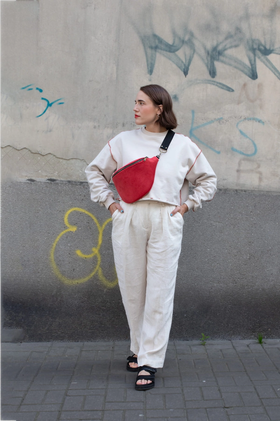 Elegancka czerwona nerka Hibiskus. Trwały aksamit. Okucia stare złoto. Prezentowana przez modelkę w rozmiarze maxi, z paskiem z czarnej taśmy 25mm. Noszona na skos, przez ramię.