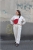 Elegancka czerwona nerka Hibiskus. Trwały aksamit. Okucia stare złoto. Prezentowana przez modelkę w rozmiarze maxi, z paskiem z czarnej taśmy 25mm. Noszona na skos, przez ramię.
