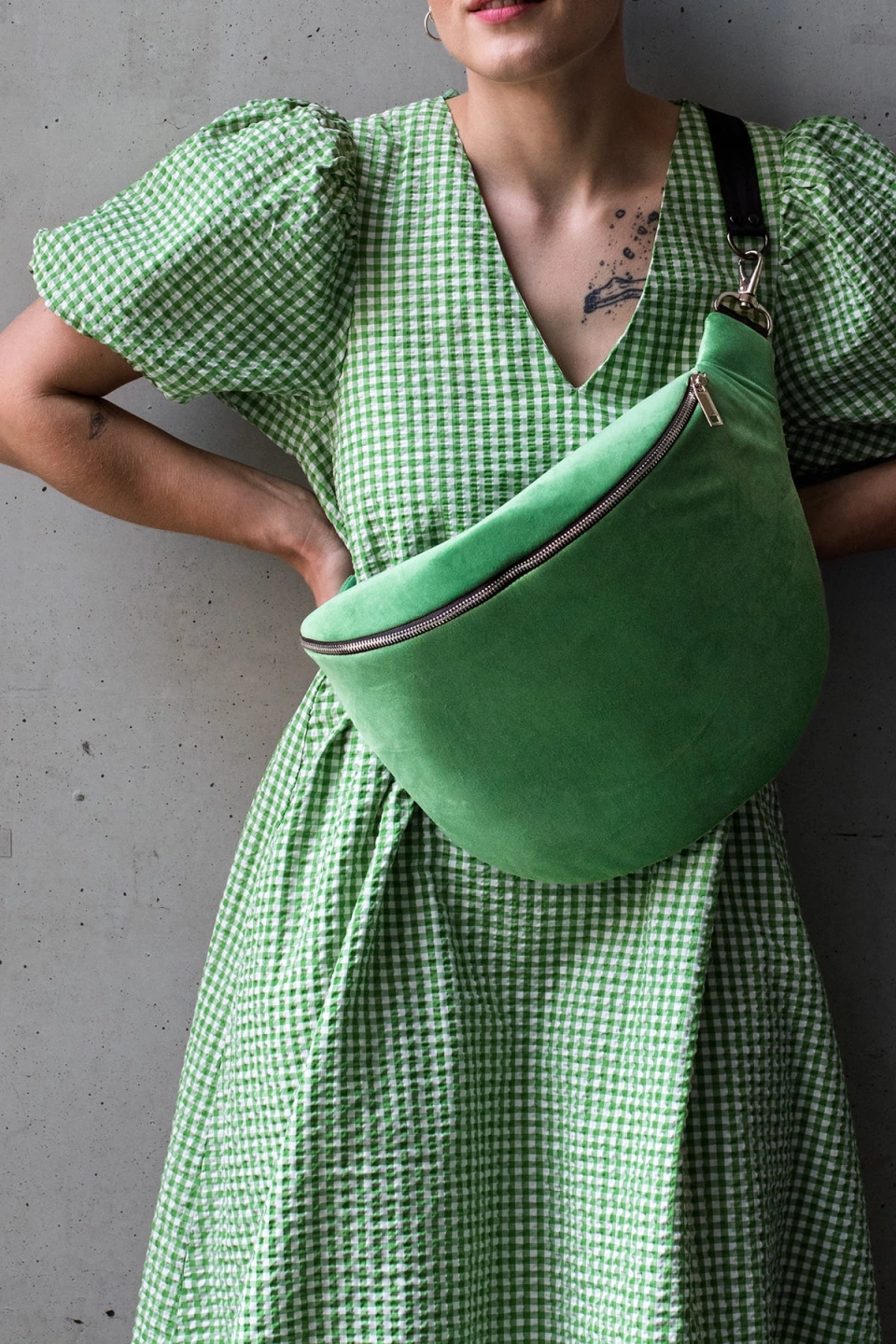 Jasnozielona nerka aksamitna, Ouiet Green. Trwały materiał. Okucia w jasnym srebrze. Prezentowana przez modelkę, w pojemnym rozmiarze cubage, z paskiem z czarnej taśmy 40mm. Noszona na skos, przez ramię.