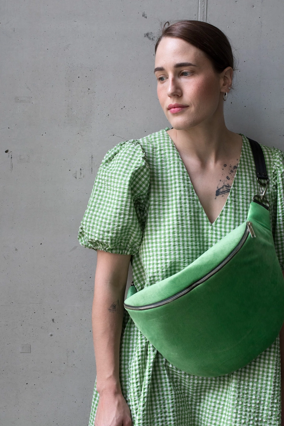 Jasnozielona nerka aksamitna, Ouiet Green. Trwały materiał. Okucia w jasnym srebrze. Prezentowana przez modelkę, w pojemnym rozmiarze cubage, z paskiem z czarnej taśmy 40mm. Noszona na skos, przez ramię.